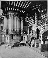 Vue intérieure : l'orgue qui se trouvait dans le grand hall. Le plafond à poutres subsiste encore dans un appartement. Photographie imprimée. Tiré de : La vie à la campagne, 1er octobre 1912.