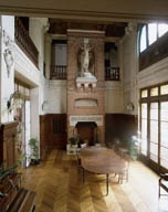 La Villa Kermina : la salle de chasse, vue en direction de la cheminée. Une galerie ouverte la surplombe sur trois côtés.