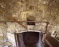 Entrée de la cave semi enterrée sous l'ancien logis détail d'une bouche d'aération au dessus de la porte.