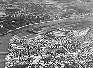 Vue aérienne de la rive sud, détail : la partie sud-est de la commune, avec le stade. On reconnaît également l'usine Baummann. Le site de la Cooper n'est pas encore occupé par l'usine actuelle. Le pont du Général Leclerc n'est pas encore reconstruit. Photographie aérienne, 1948. (AM Melun. 3 Fi 266)