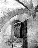 La cave médiévale : arc doubleau de la travée ouest, et accès à la travée nord (visible dans le fond).